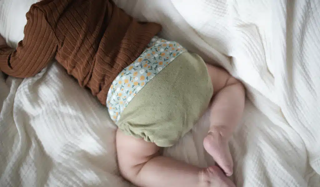 Il corpo di un bambino fotografato da dietro con un pannolino di stoffa.