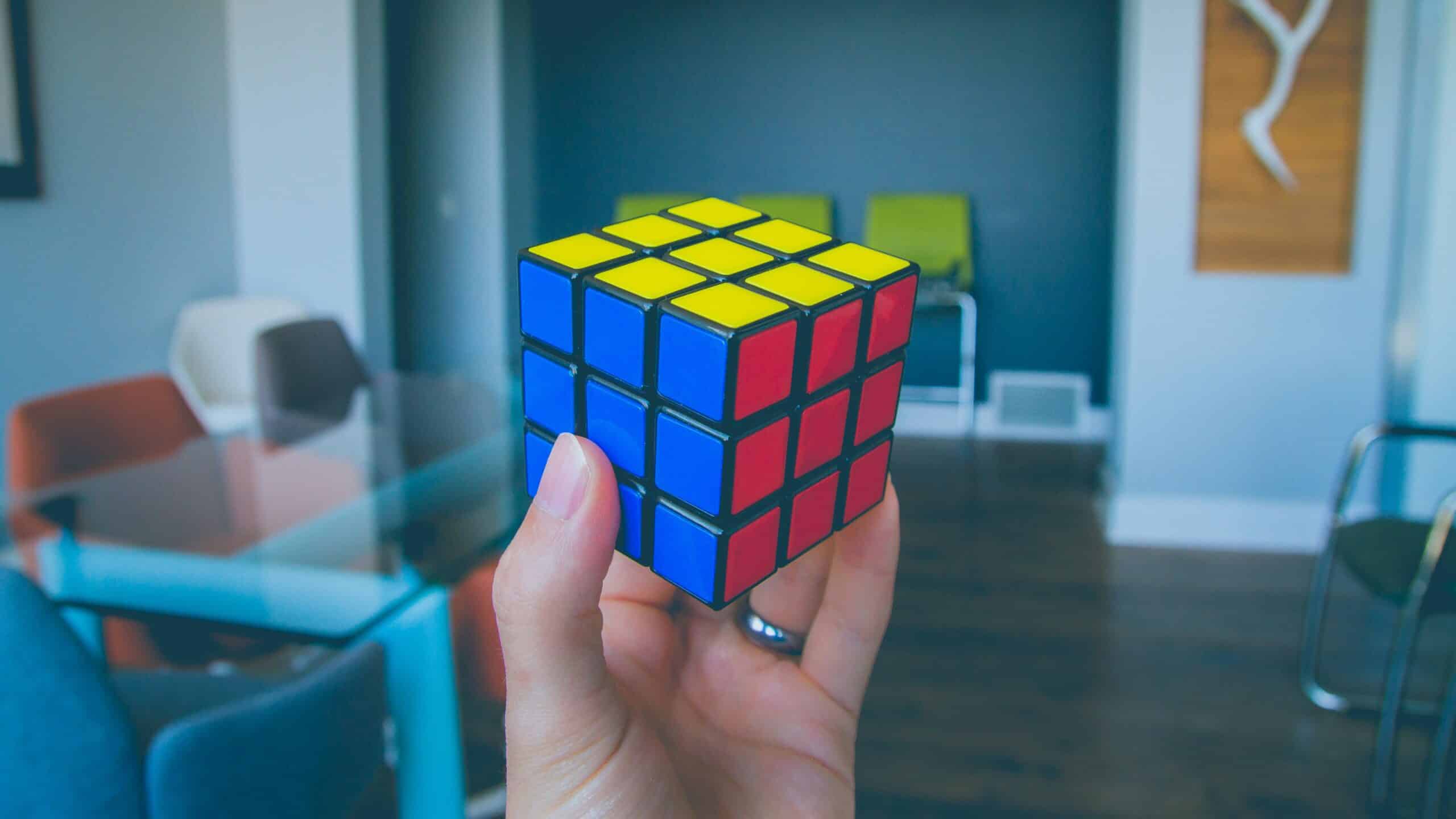 Una mano regge un cubo di Rubik risolto